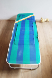 Blauwe vintage stretcher met palmboom. Retro veldbed / opklap bed