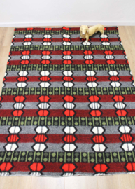 Wollen vintage deken, grijs - groen -rood. Retro sprei / plaid met grafisch patroon.