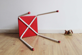 Witte vintage kruk met rode zitting. Metalen retro krukje