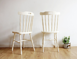 Set witte vintage spijlenstoelen. Twee houten retro stoelen.