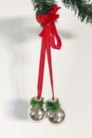 Zilveren kerstballen aan rood lint. Vintage kerstdecoratie.