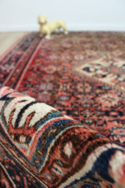 Handgeknoopt Oosters kleed rozig/rood. Uniek vintage tapijt