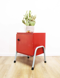 Rozig rood retro nachtkastje. Houten vintage kastje op metalen poten