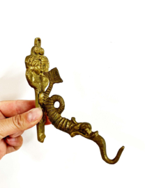 Goudkleurige haak in de vorm van een draak. Koperen vintage wandhaak