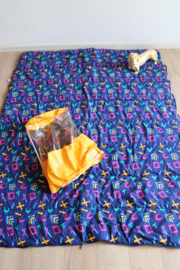 Vintage slaapzak met  jaren 90 patroon. Retro sprei/deken in gele tas