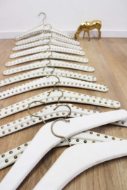 13 vintage kledinghangers van wit skai leer. Set retro kleerhangers met studs