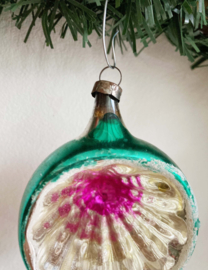 Groene vintage deukbal met paarse binnenkant. Glazen retro kerstbal