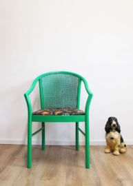 Groene vintage stoel met gebloemd kussens. Unieke retro fauteuil