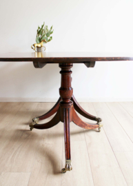 Vintage tafel met op messing klauwpoten met wieltjes eronder. Houten eettafel
