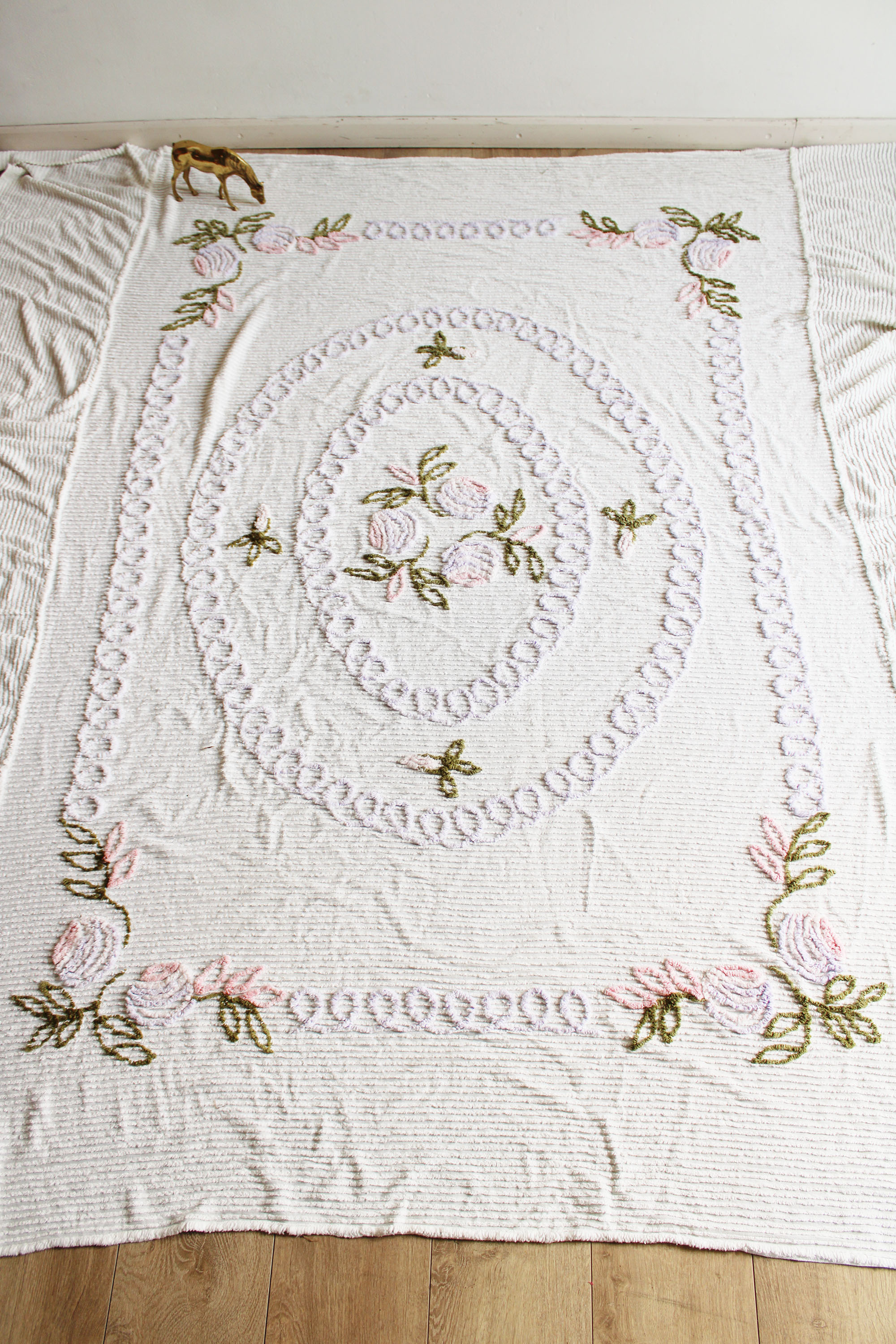 Witte vintage chenille sprei met bloemen. Retro sierdeken.