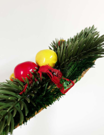 Vintage kerstkrans met dennenappels, fruit en rode linten. Retro kerstversiering
