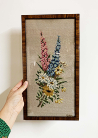 Vintage borduurwerk met veldboeket in lijst. Retro bloemen 'schilderijtje