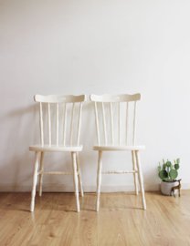 Set witte vintage spijlenstoelen. Twee houten retro stoelen.