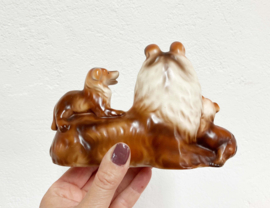 Stenen vintage honden beeldje. Retro beeld van een Collie met puppy's