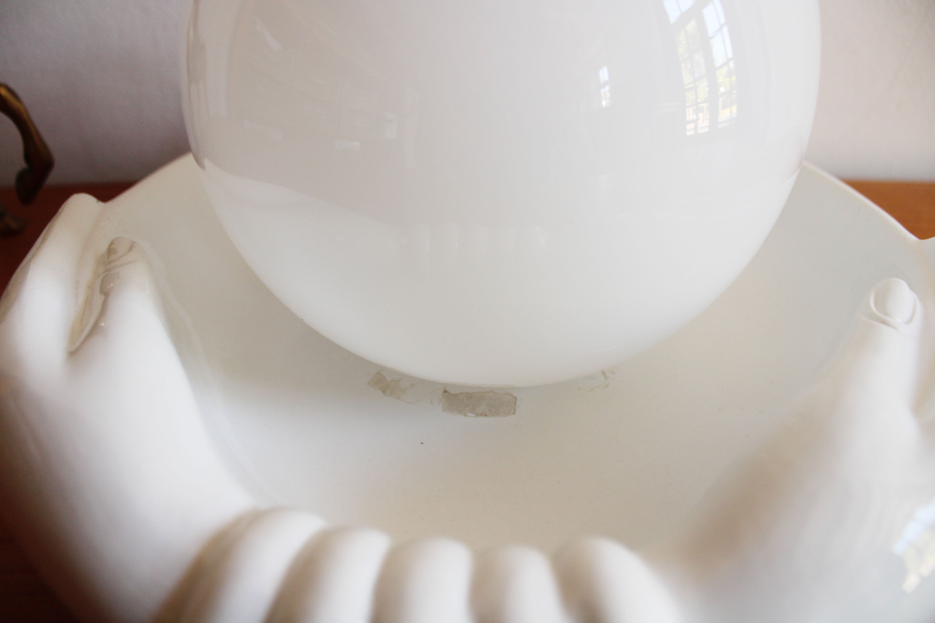 Witte vintage tafellamp, handen met bal. Keramieken retro bol lamp