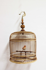 Vintage bamboe vogelkooi met sierlijke haak. Antieke kooi met vogeltje.