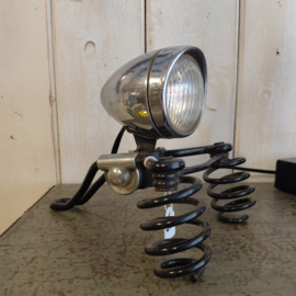 Oud fietszadel met daarop lamp gemaakt.