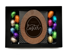 Venster met chocolade ei met gekleurde eieren