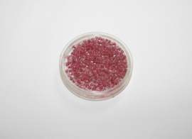 Small round box of 4 cm diameter, containing RED beads with transparent edge