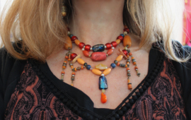 Halssnoer samengesteld uit vintage en Berber juwelen met houten, plastic, stenen en klei kralen oranje geel rood blauw