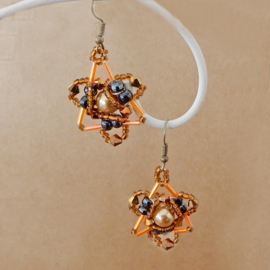 Goudkleurige parel met zwarte glaskralen, kristallen en oranje staafjes aan haken van brons
