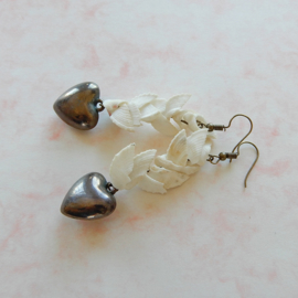 Oorbellen van witte schelpjes met hangend hart van brons (7,5 cm lang)