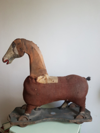 Antiek oud frans paard op plank wieltjes