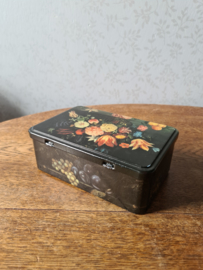 Oud zwart blikken koektrommel bloemen