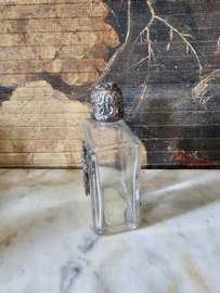 Oud glazen flesje in zilverkleurige ornament