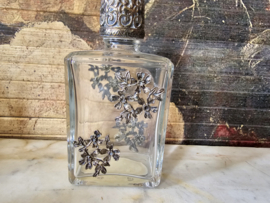 Oud glazen flesje in zilverkleurige ornament