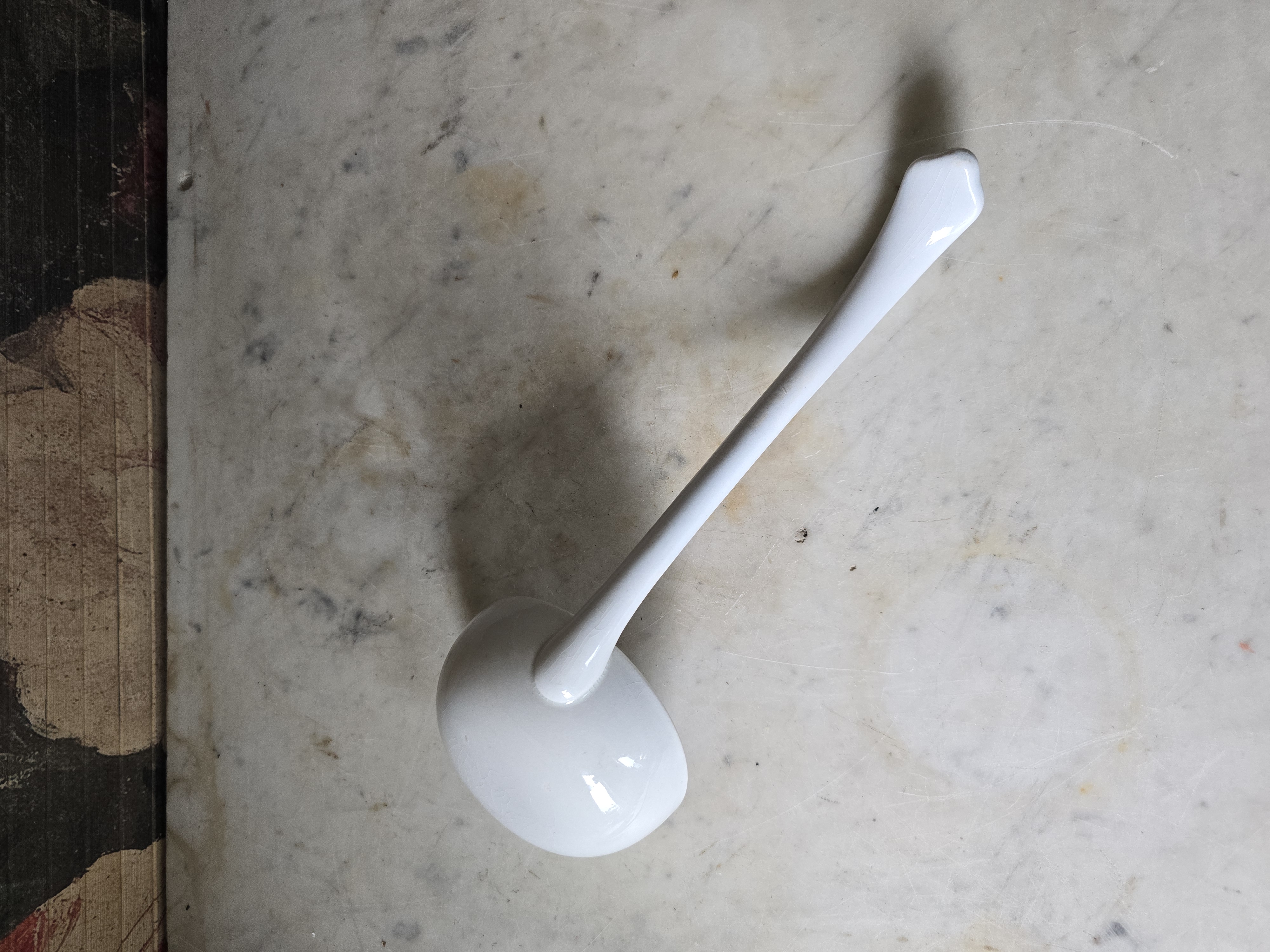 Oude witte soeplepel