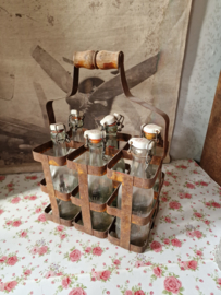 Oud flessenrek gevuld met glazen beugelflesjes
