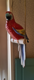Porseleinen ara papegaaien beeld op schommel