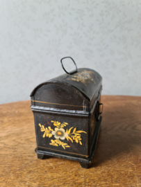Oud doorleefd zwart blikken trommeltje bloemen