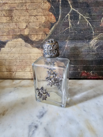 Oud glazen flesje in zilverkleurige ornament