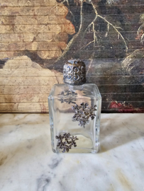 Oud glazen flesje in zilverkleurige ornament