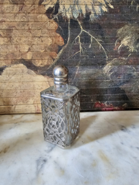Oud glazen flesje in zilverkleurige houder