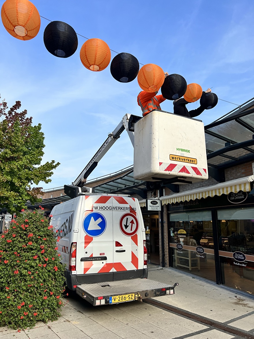 Halloween lampionnen montage aan staalkabels met hoogwerker