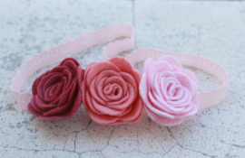 Handgemaakte haarband met drie vilten rozen in oudroze, licht oudroze en lichtroze
