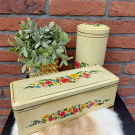 Vintage beschuitblik en ontbijtkoekblik met bloemen op craquelé achtergrond