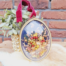 Vintage lijstje met bol glas met daarin een droogbloemen boeket