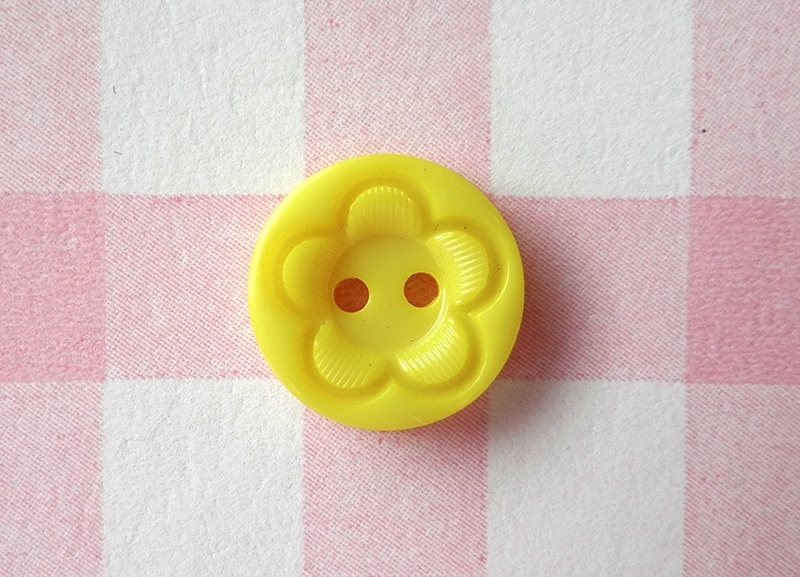 Knoop rond met bloem geel