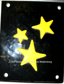Drie gele sterren op zwart glas