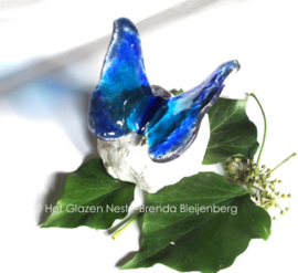 Speels blauwe vlinder in lichtdoorlatend glas