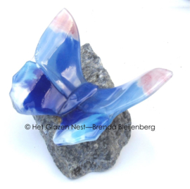 Roze en blauwe vlinder op blauwe steen