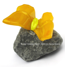 Vlinder op steen in rustig geel