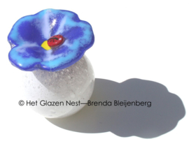 Glazen bol-urn met lieveheersbeestje op bloem