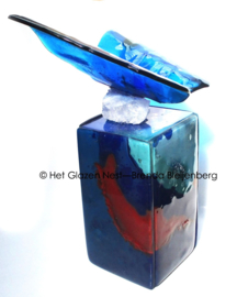 Blauwe glazen vlinder op gekleurde urn-zuil