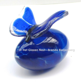 Blauwe vlinder op mond-geblazen steen