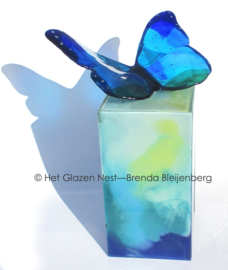 Blauwe vlinder op zee groene urn zuil